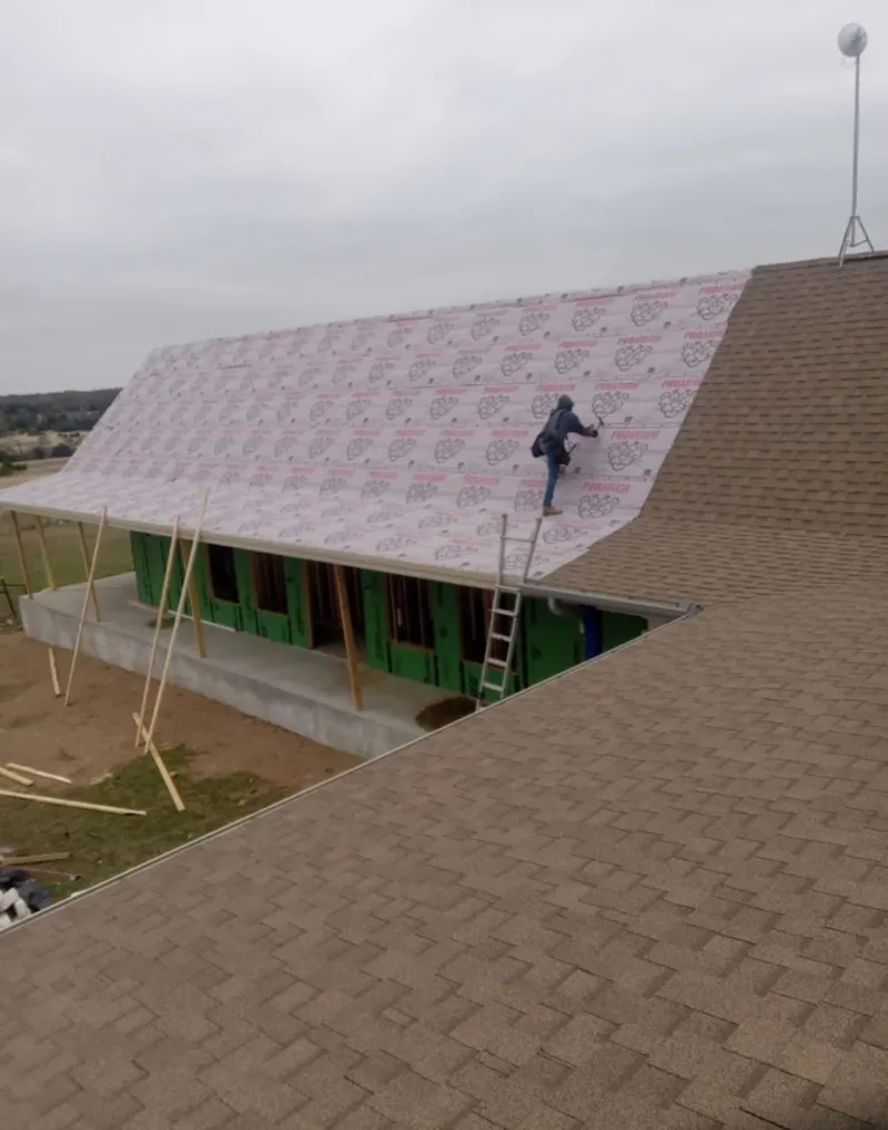 Worker preparing underlayment for a metal roof installation in Campton Hills